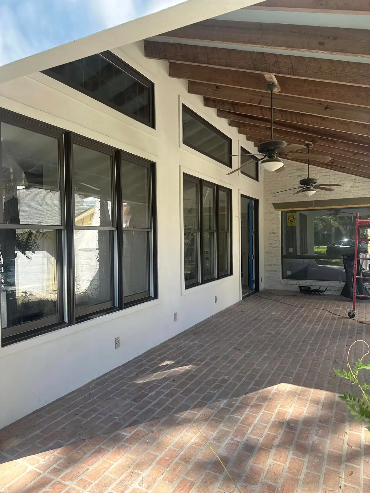 Covered porch with fresh stucco walls under exposed wood beams